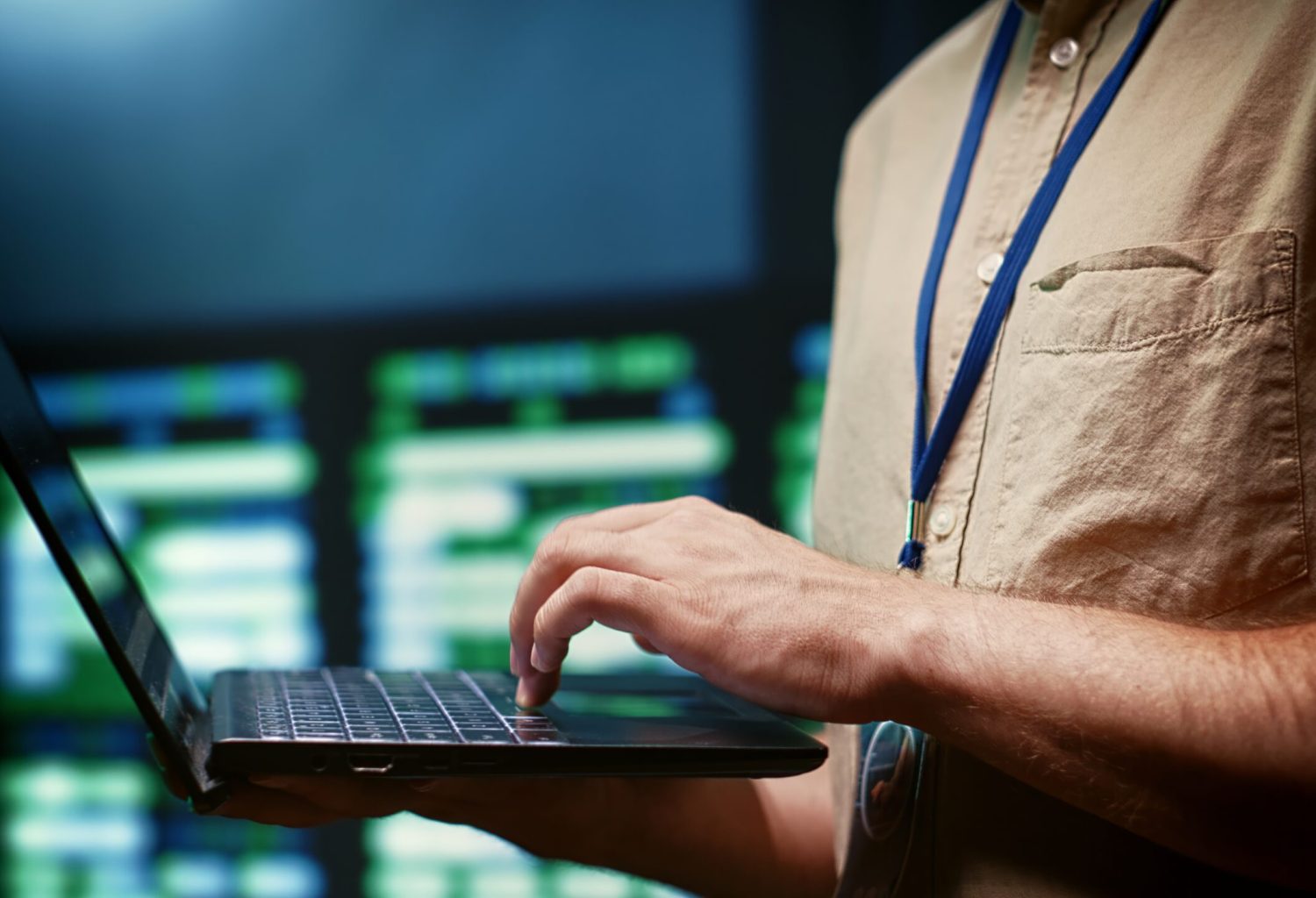 IT developer using laptop to monitor server farm security to protect information access, making sure virus protection software is updated and hackers trying to penetrate systems are rejected, close up